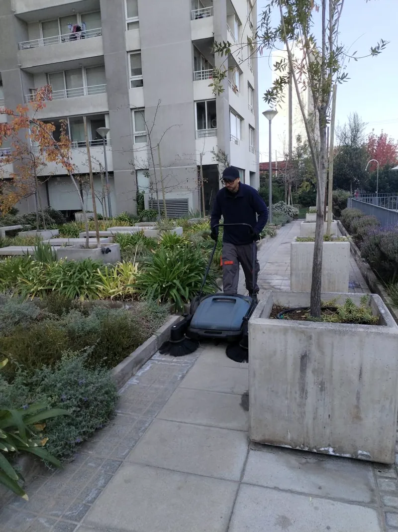 Colaborador de 3D Group operando una barredora en los exteriores de un edificio